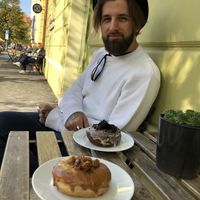Tables on the sidewalk to enjoy the local neighborhood and culture. Tree lined street with some cute shops in the neighborhood   at Donut Shop in Prague