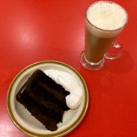 A slice of vegan choc fudge cake with whipped cream and soya latte. at Beach House Cafe in Great Yarmouth