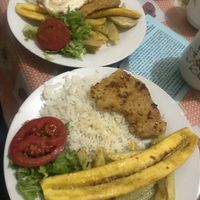 Main dish with lettuce, tomato, rice, plantain, and soy meat at Comedor Vegetariano in Cusco