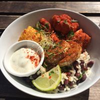 Buddha bowl - bbq cauliflower, tempeh, rice with black beans, corn on the cob with a creamy white sauce (tasted kind of like sour cream or tziki).  at Comptoir Veggie in Paris