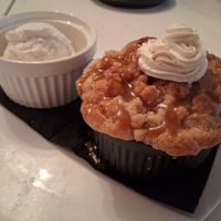 Peach Cobbler: fresh peaches, buttery crumble topping served with cashew caramel & whipped cream plus a side of ice cream at P.S. Kitchen in New York City