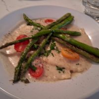 White Bean Ravioli in a garlic creamy "parmesan" sauce topped with grilled asparagus and cherry tomato at P.S. Kitchen in New York City