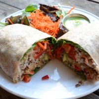 Chicken-Free Pesto Wrap (vegan):
Seasoned and stir-fried organic “chicken-style” seitan, organic wild rice, our own home-made vegan pesto sauce, chopped tomatoes, fresh avocado, diced red bell peppers, organic baby spinach, organic shredded carrots at Fudenjuce in Nevada City