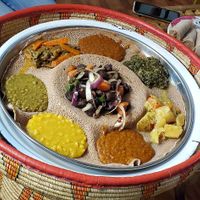 Vegan beef tibs with veggie platter around it at Ghion Cultural Hall in Atlanta