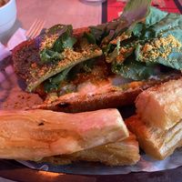 Meatball sandwich with fried yucca. Hard to see the meatballs under the greens. Meatball is made of beets. at Huacamole Vegan Food in San Pedro