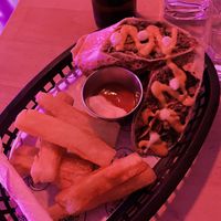 Burrito with yucca fries, yummy cashew cream drizzle  at Huacamole Vegan Food in San Pedro