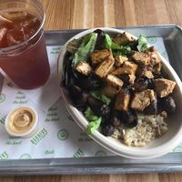 Citrus tofu with brown rice, sautéed mushrooms, field greens, and a coconut thai curry sauce. at Beehive Kitchen - Andrews Ave in Fort Lauderdale