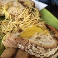 Vegan grilled cheese sandwich with tomatoes, onions, mustard and vegan sausages  at Veggie Momi in Albufeira