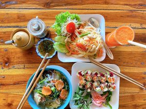 Papaya salad, glass noodle soup, spring rolls, carrot, ginger, and orange juice.  at Aum in Chiang Mai
