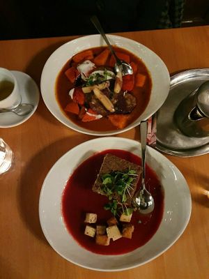 Oben: Kürbisgulasch mit Walnussknödel und Apfel; Unten: Pastinakengratin auf Roter Beete Creme und Räuchertofu at Hollerei in Vienna