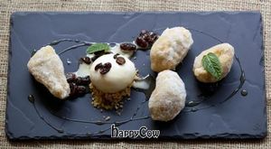 Hot banana fritters in a rum batter with soaked raisins and vanilla ice cream (v) at Food For Friends in Brighton