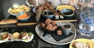 Vegan spread: bread and olives, Thai cauliflower, fries, king oyster mushrooms, crispy tofu  at Food For Friends in Brighton