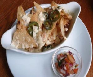 nachos grande (vegan): organic hand fried tortilla chips, jalapeno chillies, melted mature cheddar, and salsa at The Warehouse Cafe in Birmingham