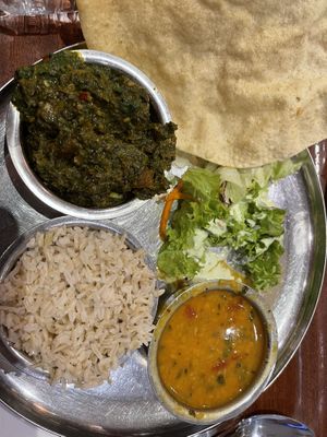 Menu with three dishes. Rice, lentils and potatoes with spinach    at Govinda's in London