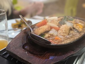 Sizzling fish dish, comes to the table with the drama of steam and the sizzling noise coming from the hot plate. at Loving Hut in North London