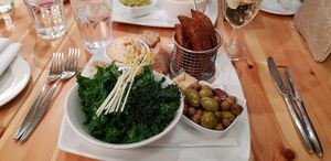 Mixed side dishes - hummous, wedges, olives and kale. at Manna London Restaurant - Maybe closed in North West London