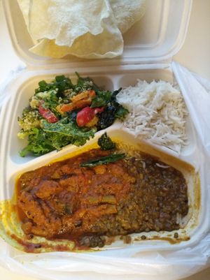 Take-away-box with curries, rice, some salad, and poppadums. at Gopal in Tampere