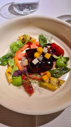 Tempeh brasato, pomodoro costoluto, crudo e confit, taccole e zucchine gialle alla griglia, fumo di legno di ciliegio, pesto di basilico e altri contrasti at Joia Alta Cucina Naturale in Milan