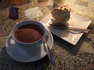 Chocolate a la taza con dulce relleno de pera en almíbar y crema  at Jardin Urbano in Valencia