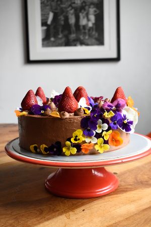 Pastel de chocolate con decoración de flores comestibles. at Veganeria Le Muf in Mexico City