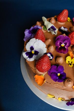 Pastel de chocolate con decoración de flores comestibles. at Veganeria Le Muf in Mexico City