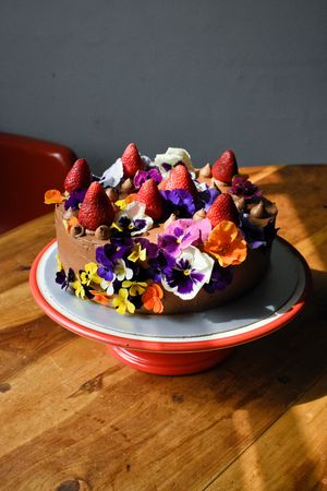 Pastel de chocolate con decoración de flores comestibles. at Veganeria Le Muf in Mexico City