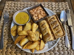 Vegan sausage roll with chips, beans and curry sauce, $5.75  at New Leaf Eatery in Siem Reap
