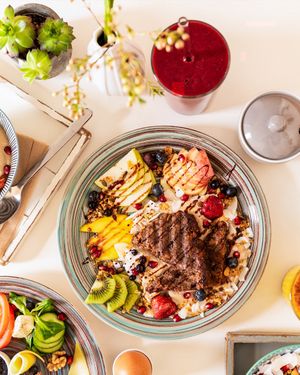 Power-Frühstück (vegan): hausgemachtes Bananenbrot, Cashew-Joghurt & Granola mit Ahornsirup, frischem Obst, Kokosraspeln und Schokosauce  at Brocca Cafe in Berlin