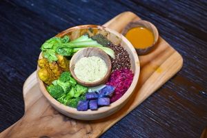 Macrobiotic Rainbow Bowl with matcha hummus, turmeric tempeh, sautéed greens, steamed purple sweet potato, red quinoa, pink beetroot & fennel sauerkraut, spirulina & wakame gomashio & goji vinaigrette at Matcha Cafe in Tibubeneng