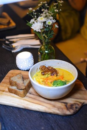 Malaysian Laksa Curry Soup - Warming, spicy, flavourful soup made using house-made laksa paste with anti-inflammatory fresh turmeric root, lemongrass, ginger & creamy coconut. A soupy stew of rice noodles, fragrant herbs, alfalfa sprouts & crunchy vegetables, topped with tempeh, fried shallots & lime at Matcha Cafe in Tibubeneng