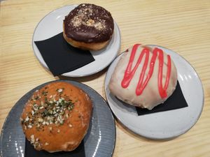 Snickers donut, donut relleno de frambuesa con chocolate blanco y donut relleno de crema de queso at Delish Vegan Doughnuts in Madrid