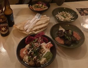 Hummus plate and eggplant salad beside Israeli beer  at Akko Hummus Bar in Leipzig