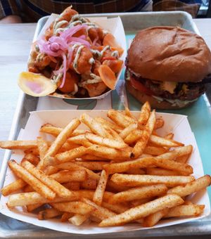 Classic Burger (mushroom lentil patty, smoked portobello, queso, magic sauce, lettuce, tomato, and pickles), BBQ fries, and buffalo cauliflower. Photo taken April 2018. at PLANTA Burger in Toronto