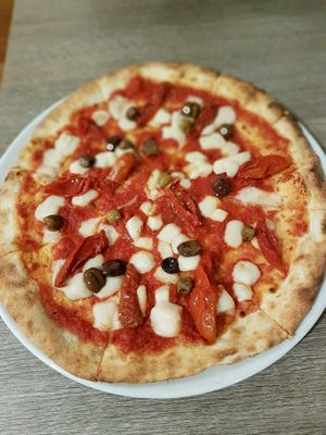 Pizza with mozzarisella and Taggiasche olives  at Calico Ristorante Pizzeria in Treviso