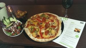 Vegan pizza, side salad, potato wedges & vegan wine. at Rock Garden in Torquay