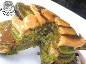 Matcha pancakes layered with almond, cashew and peanut butter and served with homemade salted caramel sauce and in season fruits.  at Bom Bowls in Pai