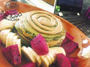 Matcha pancakes, vegan, Green, delicious and filling. Layered with almond, cashew and peanut butter, served with our homemade caramel sauce and fruit.  at Bom Bowls in Pai