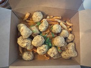 Butter Curry over Fries with Vegan Popcorn Chicken- tomato & “butter” based sauce sauteed with onion & served over french fries at Foo Dog Curry Traders in Jacksonville