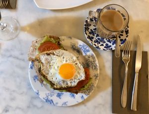 Oat milk coffee with egg, tomato and avocado sourdough toast. at Blu Cafe in Santiago De Compostela