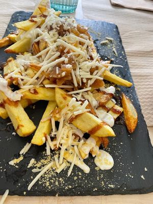 Papas Locas: fried Lanzarote potato wedges, with sauces, vegan cheese and caramelised onions at Veggie Penguin in Tenerife