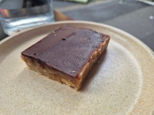 Caramel slice $7.50: delicious, lovely crunchy texture of biscuit, caramel, and chocolate, although noticeable coconut taste at Shift Eatery in Surry Hills