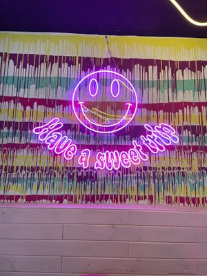 Neon sign on the colorful wall at Freedom Cakes Bakery in Madrid