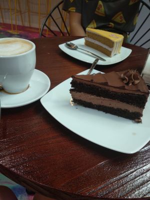 Tarta de fruta de la pasión, café con leche de arroz y tarta de muerte por chocolate. at Freedom Cakes Bakery in Madrid