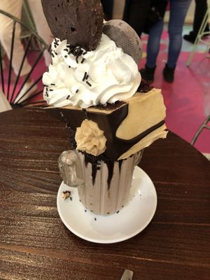 Chocolate freak shake with a slice of peanut cake, chocolate palmeritas and whipped cream at Freedom Cakes Bakery in Madrid