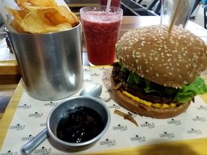 Soy burger, vegan cheddar, coconut "bacon", greens, tomato and carmelized onions, fresh chips, guava bbq sauce and a strawberry mint juice!!  at Goodala Burger in Natal