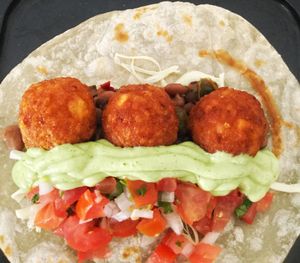 Mexican burrito comes with chili beans, cheese, 3 Mexican PapaTots, pico de gallo and avocado cream. at Papa Tots in Puerto Escondido