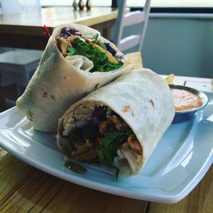 The "Super-Popular Wrap": kalamata olive hummus, house seasoned seitan, red onions, cucumbers and greens in a locally-made flour tortilla. at Two Dollar Radio Headquarters in Columbus