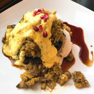 Stuffed Portobello Benedict - Coconut-curry stuffing, roasted portobello mushroom, cashew sour cream, sautéed spinach, hollandaise sauce, & pomegranate reduction. at Detroit Street Filling Station in Ann Arbor