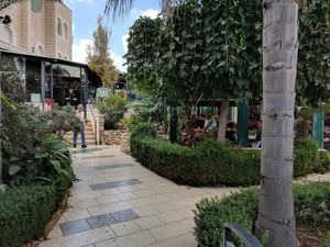Garden seating area with indoor seating behind at Naurah in Abu Ghosh