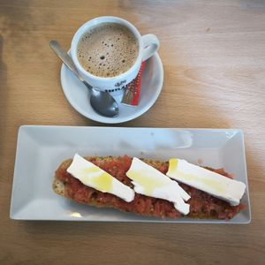Café con bebida de avena y tostada con tomate rallado y camembert at Vegan Bombon in Alicante